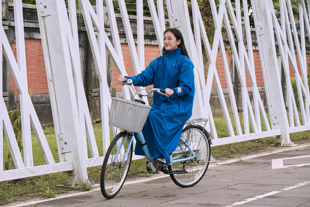 レインコートのMORRを着て自転車に載る女性